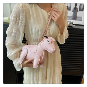 Detailed view of a pink horse-shaped PU leather crossbody bag worn by a model