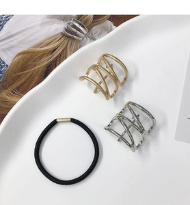 Detailed flat lay of minimalist gold and silver metal ponytail hair clips with black cord