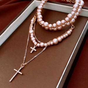 Elegant multi-layer pearl necklace with sparkling diamond-encrusted cross pendants