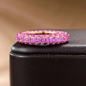 Macro shot of rose gold eternity ring with pink cubic zirconia stones on display