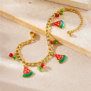 Bracelet à maillons dorés avec breloques pastèque et perles colorées sur fond de pierre