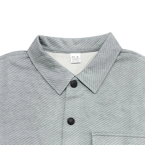 Close-up of gray twill jacket with standard collar, size label, and matte black buttons