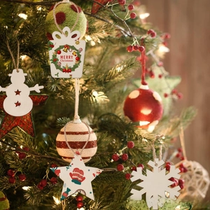 Detail of DIY Christmas wooden ornaments hanging on tree with festive warm light decorations
