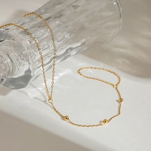 Détail de la chaîne en acier inoxydable doré 18 carats avec perles sur verre