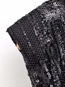 Détail macro de paillettes noires cousues sur un tissu en maille pour robe de soirée