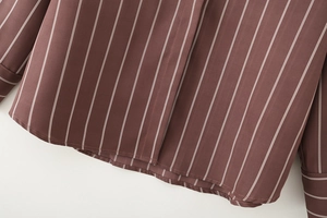 Close-up of coffee brown striped shirt fabric showing hem and cuff texture details