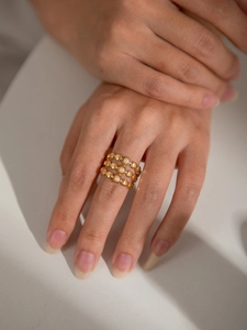 Detailed view of an 18K gold triple-layer beaded ring featuring round white pearls on hand