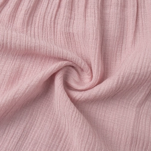 Detail of light pink crepe fabric showing natural crinkle texture and soft breathable material