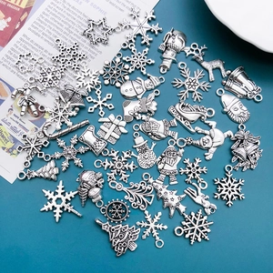 Close-up of vintage silver alloy Christmas pendants featuring Santa and snowflake designs