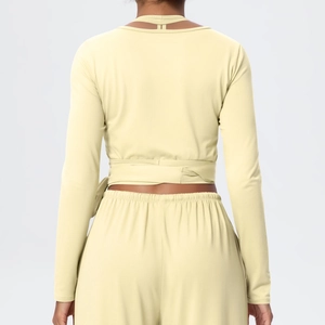 Detail of cross-tie back design on light yellow long sleeve yoga crop top and leggings