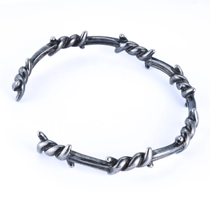 Detail of vintage silver thorn wire style open bangle with rustic metal texture
