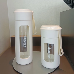 Minimalist white glass tea cups with insulated shell and silicone handles in two sizes
