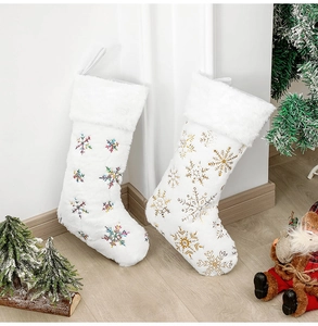 Détail de chaussettes de Noël en peluche avec broderie de flocons de neige pailletés dorés