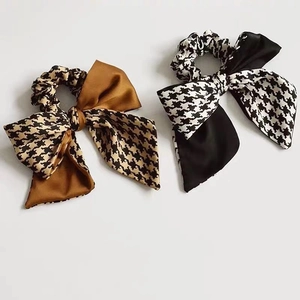 Elegant houndstooth and satin bow scrunchies in brown and black on white background