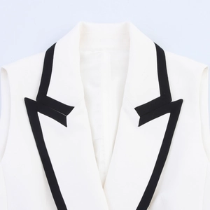 Detail of V-neck white waistcoat with contrasting black trim and premium suit fabric texture
