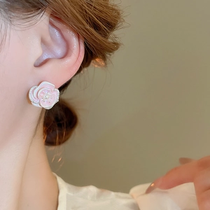 Detail of pink floral earrings with cubic zirconia edges and a center pearl inlay