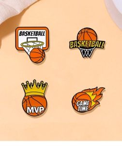 Close-up of four crown basketball enamel pins with MVP and Game Time text on orange base