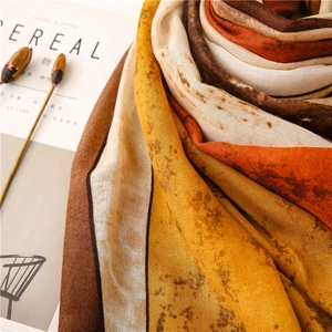 Macro detail of Earth-tone ink wash scarf showing soft fabric texture and artistic prints