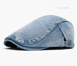Detail of light blue denim flat cap with distressed edges and metal buckle side view