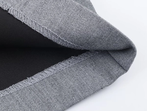 Macro detail of the grey crepe fabric showing precise double-line stitching on the hemline