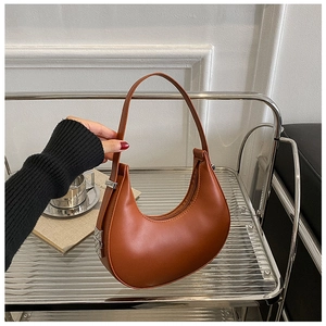 Detail view of brown leather hobo bag with metal buckle and top zipper closure