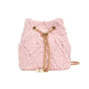 Detail of pink denim bucket bag featuring gold chains, pearl drawstrings and fringe texture