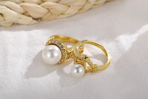 Macro detail of gold-plated rings with white pearls and sparkling diamond accents