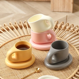 Minimalist ceramic chubby coffee mugs with matching saucers in a natural rattan tray