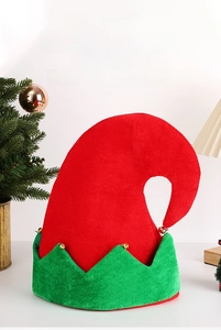 Detail of red and green elf hat with gold bells on a festive indoor Christmas background