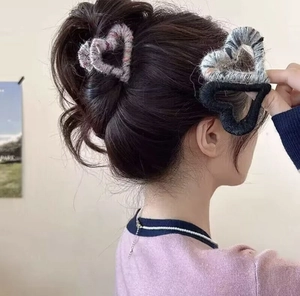 Model wearing a heart-shaped plush hair claw clip in a natural side view hairstyle