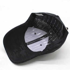 Detail view of black corduroy baseball cap interior with white care label and support