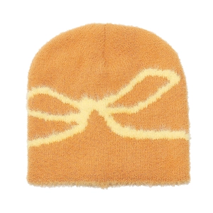 Detail of soft plush knit beanie with bow jacquard pattern in warm brown orange hue