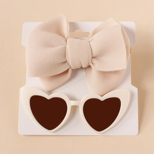 Baby gift set featuring a soft cream bow headband and white heart-shaped sunglasses