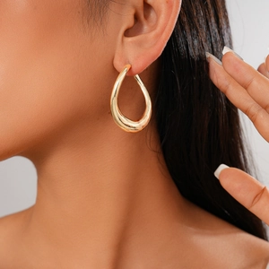 Close-up of elegant gold teardrop earrings worn by a model for a stylish look