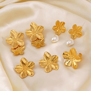 Golden flower earrings and pendants with pearls on luxury champagne silk fabric