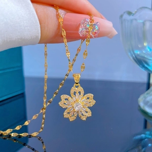 Vue macro du pendentif fleur doré orné de zircons étincelants sur une chaîne fine