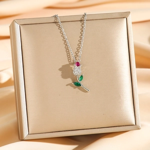 Elegant tulip zircon pendant necklace with red gemstone and silver chain on champagne satin