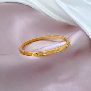 Detail of a gold-plated stainless steel bracelet with marquise zircon evil eye design