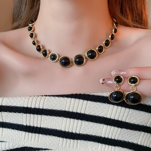 Detail of French vintage gold resin necklace and earrings set worn by a model