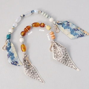Detailed view of silk scarf handbag chain with 1.6cm and 2cm resin beads and gold clasps