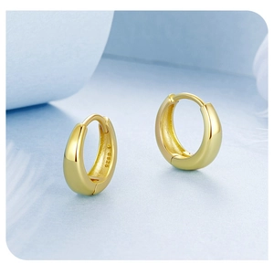 Close-up of gold-plated S925 sterling silver hoop earrings with visible hallmark