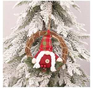 Détail d'un pendentif gnome de Noël avec tresses sur couronne de rotin pour décoration