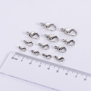Polished silver lobster clasps in 11 sizes with ruler for precise dimension comparison