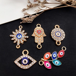 Detailed close-up of colorful Evil Eye and Hamsa Hand gold alloy charms for DIY jewelry