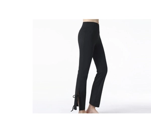 Detail of high waisted yoga pants with side slits and bow tie knots at the flared hem