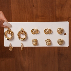 Set of 5 golden geometric earrings featuring heart shapes and textured metallic hoops