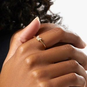 Close-up of golden butterfly ring with sparkling diamonds on a model's finger