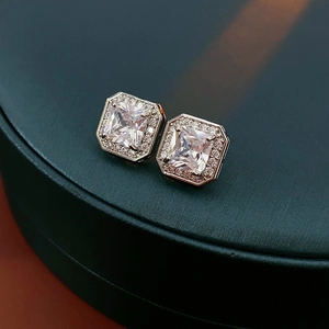 Vue macro des boucles d'oreilles carrées en or rose avec zircon et sertissage pavé