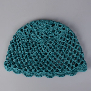 Détail du chapeau en crochet fait main bleu sarcelle avec bord ondulé et maille ajourée