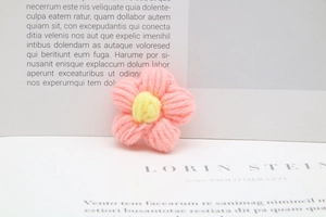 Macro shot of handcrafted pink and yellow milk cotton crochet flower accessory